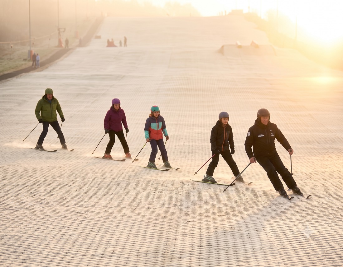 An instructor leading a small group of skiers down the slope in a lesson