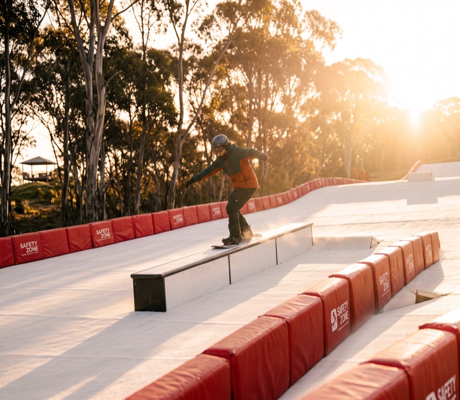 A snowboarder sliding a rail on the features line